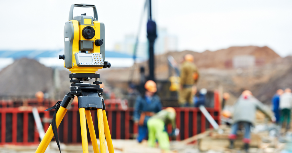 a team of land surveyors working diligently on a construction site